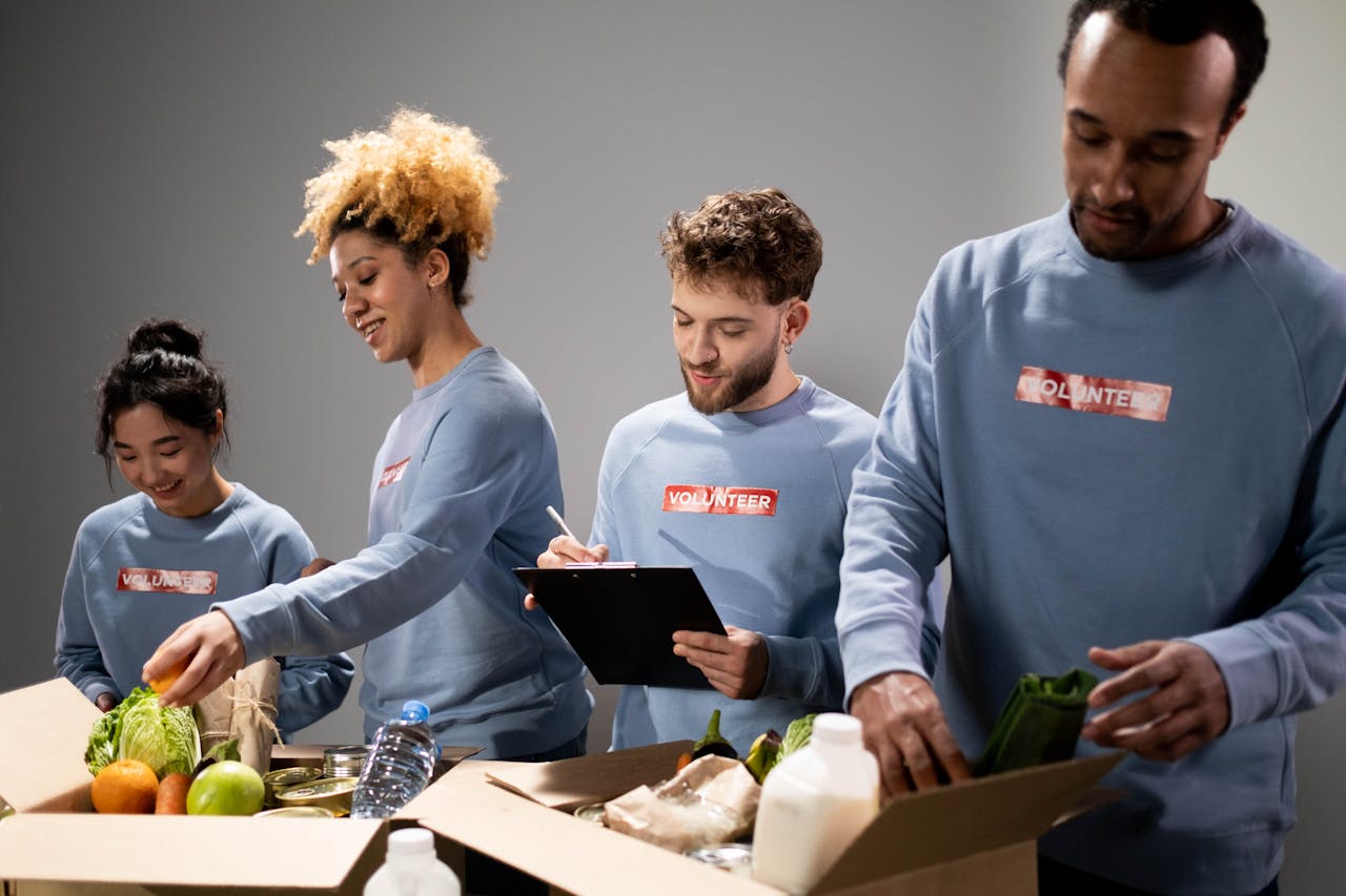 Four diverse volunteers pack food donations with teamwork and dedication.